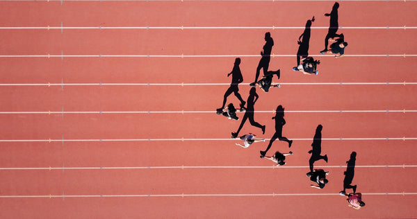 Overhead shot of runners on a red track.