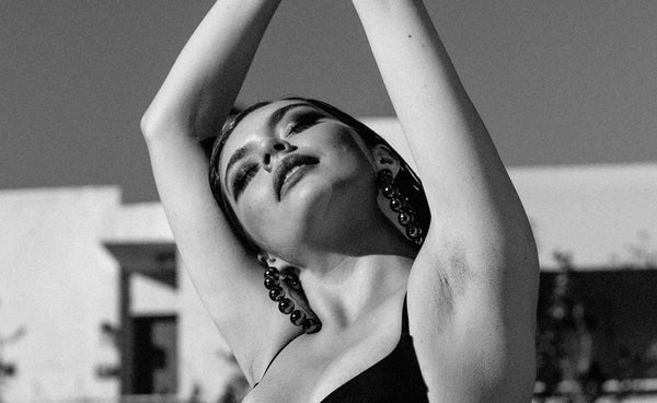 A white woman arms outstretched in the sun.